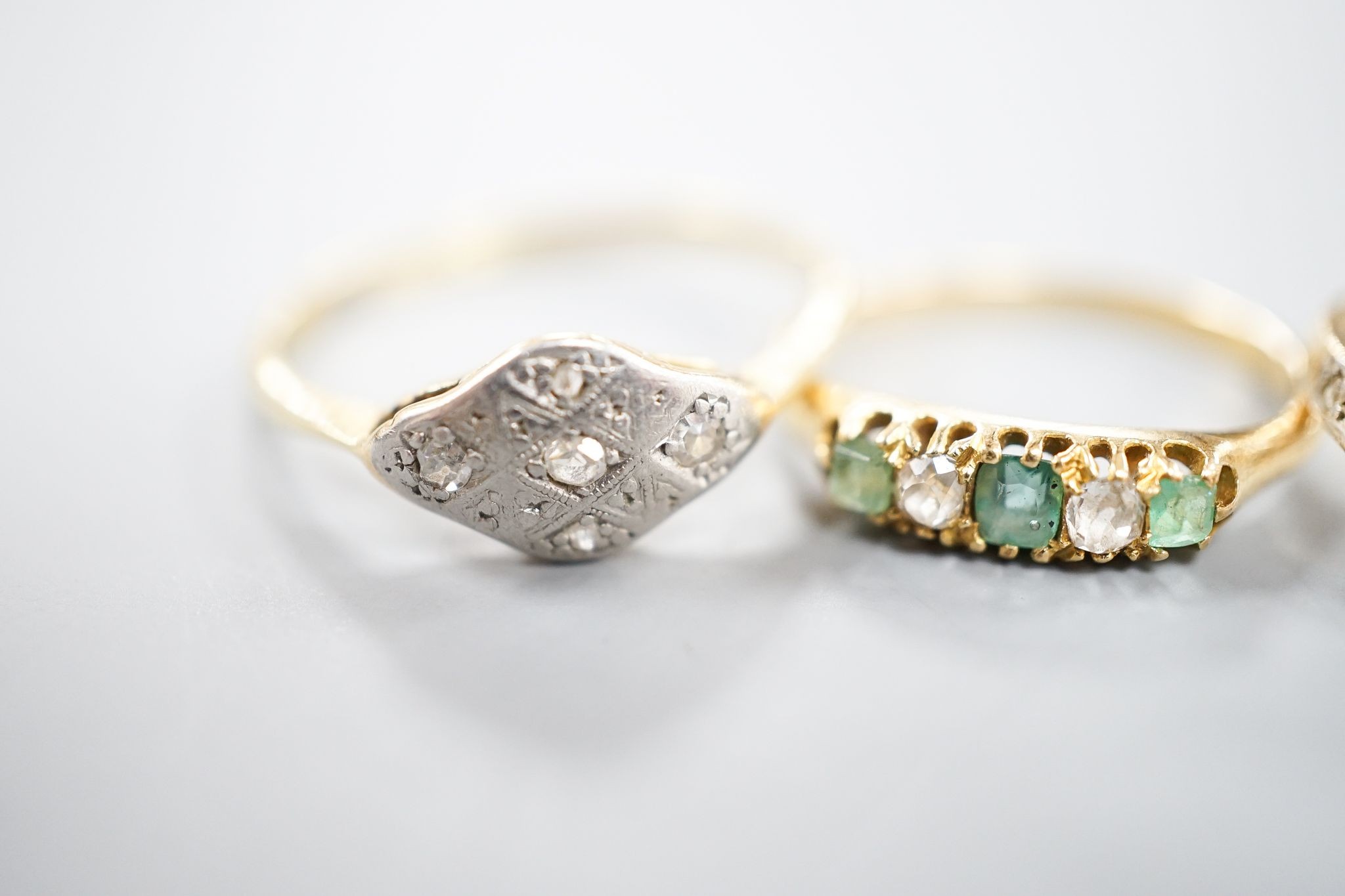 Two 18ct, plat. and diamond chip set dress rings and an 18ct, emerald and diamond set five stone ring, sizes P,I and H/I, gross weight 6 grams.